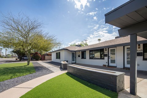 A modern house with a white exterior and a grey roof.